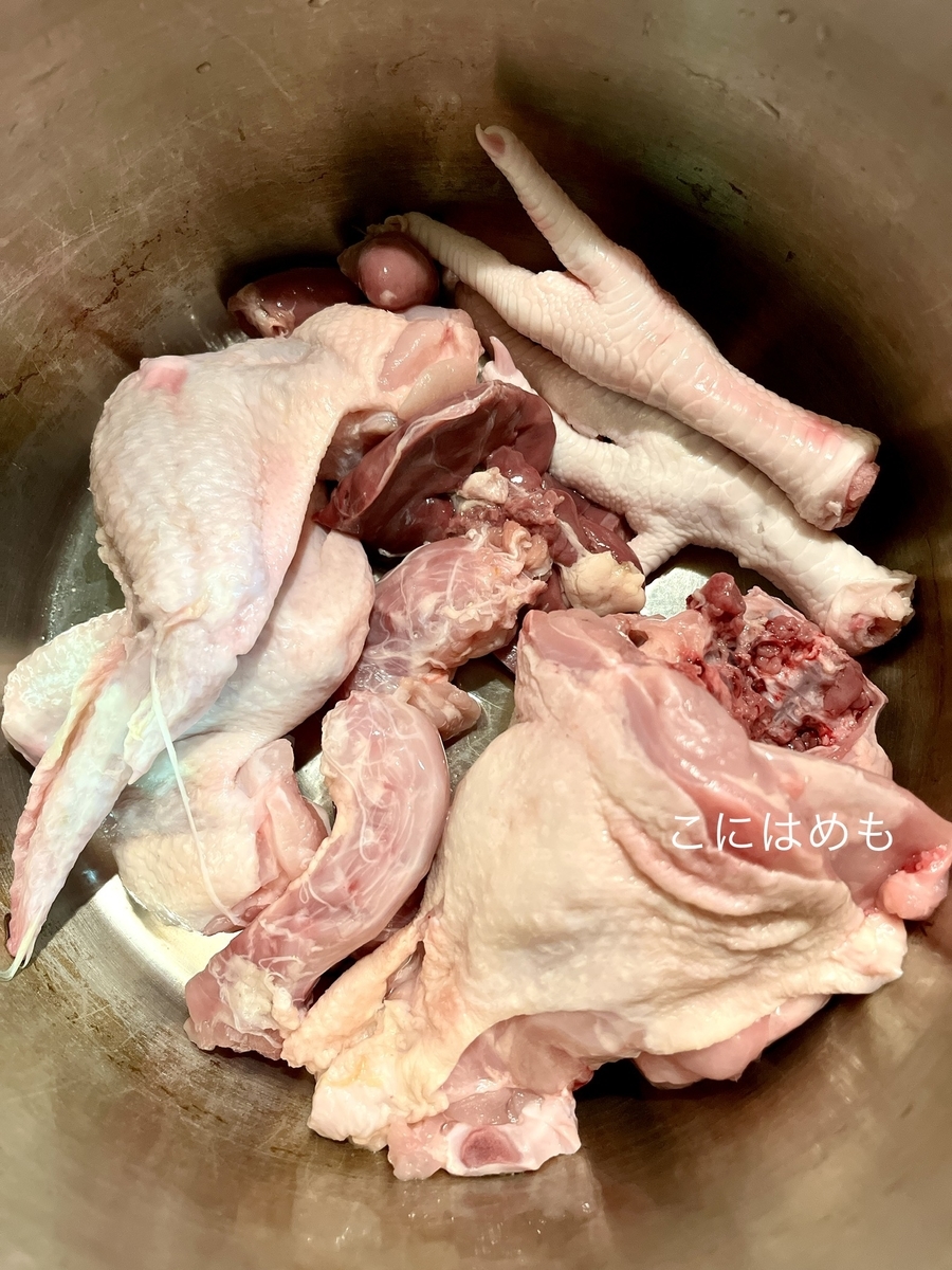 圧力鍋に材料、鶏胸肉、玉ねぎ、生姜、人参、パセリ、塩、こしょう、ローリエ、白ワイン、水を入れて火にかける。