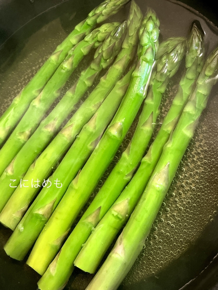 フライパンでアスパラを下茹でし、生ハムを巻きつける。