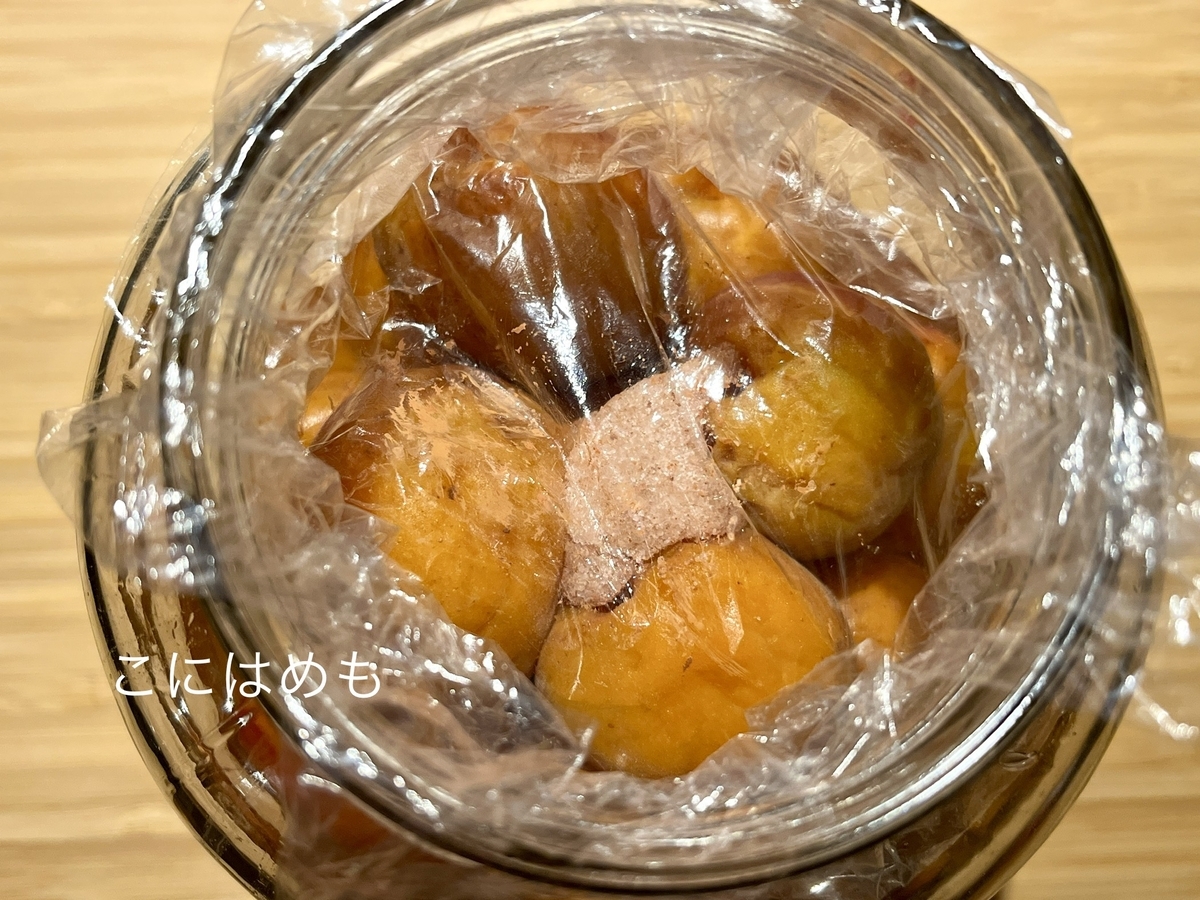 梅酢に浸かるように重石をする。