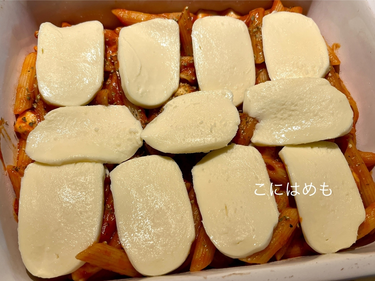 耐熱容器にパスタを入れて、ドライオレガノ、モッツァレラチーズをのせてオーブンで焼く。