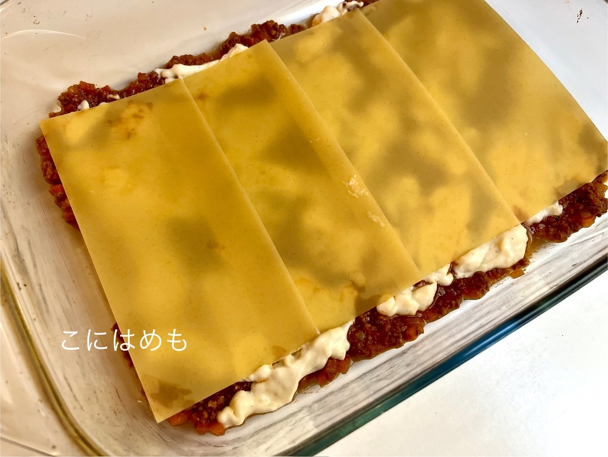 耐熱容器にボロネーゼソース、ベシャメルソース、パルメザンチーズ、チーズ、パスタと重ねていく。