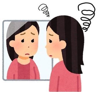 悲しそうに鏡を見ている女性