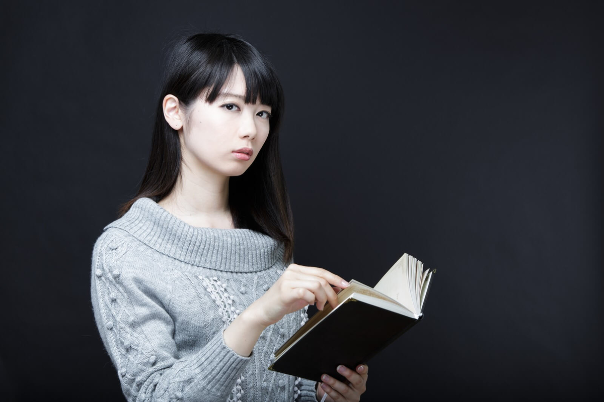 立ちながら本を読む女性