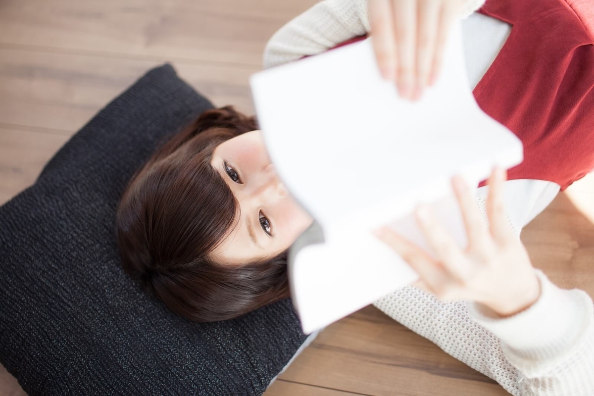 寝転んで本を読む女性