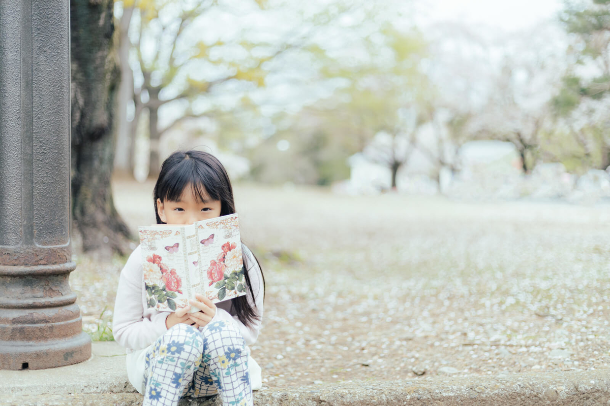 外で本を読む子供