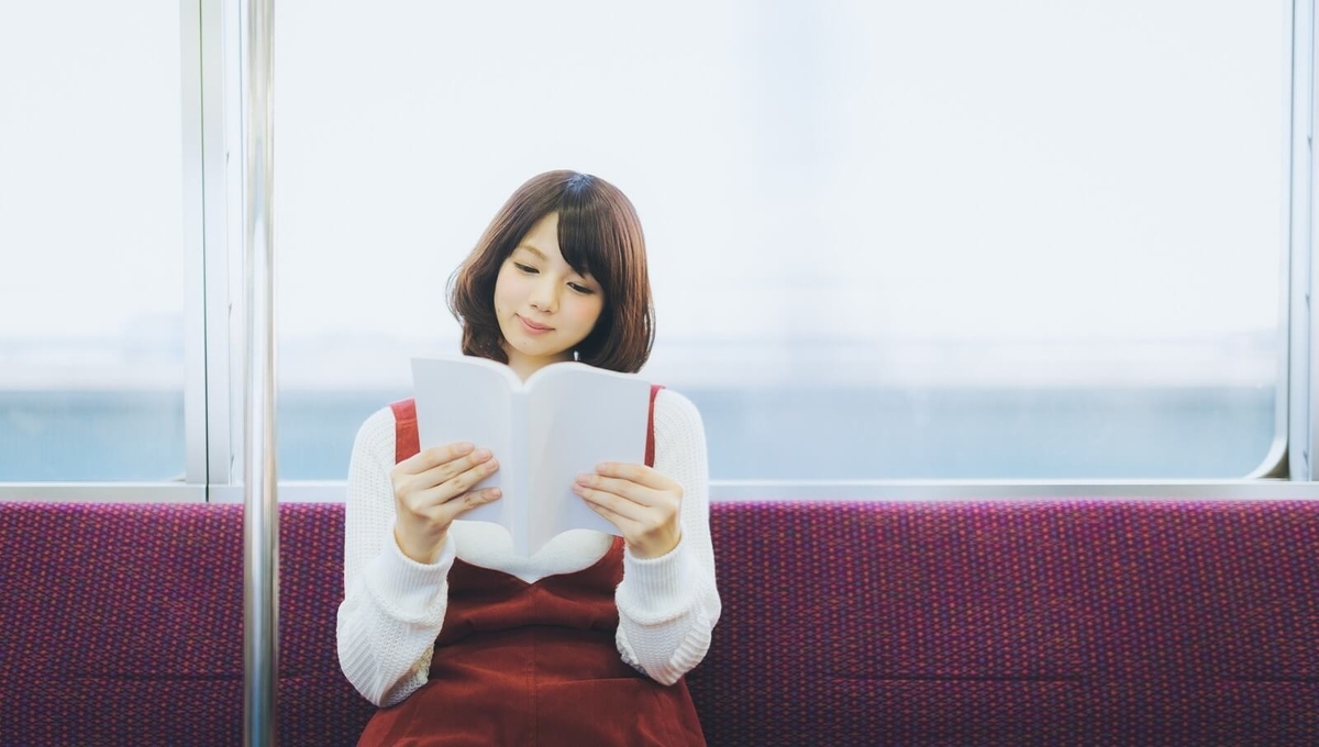 電車で本を読む女性