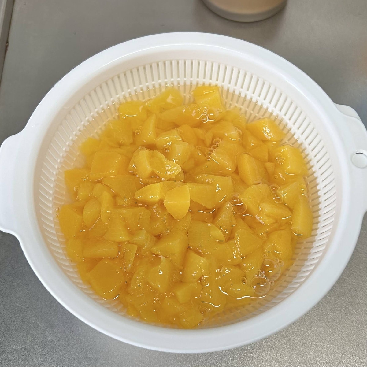 ザルとボウルの中に入っている黄桃