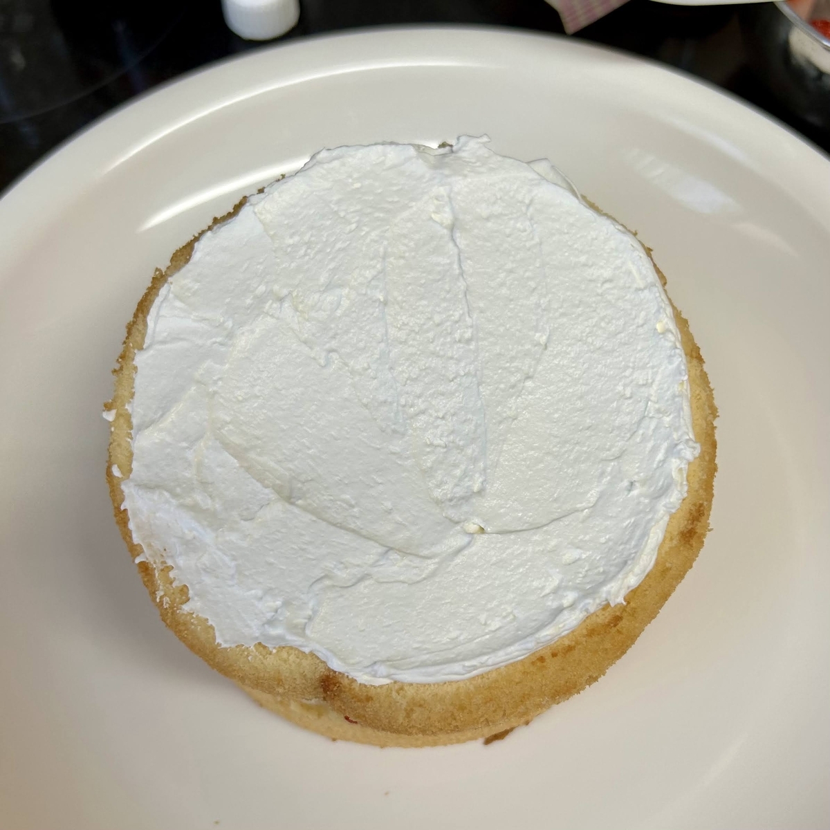 スポンジケーキの上にホイップクリームを塗ったところ