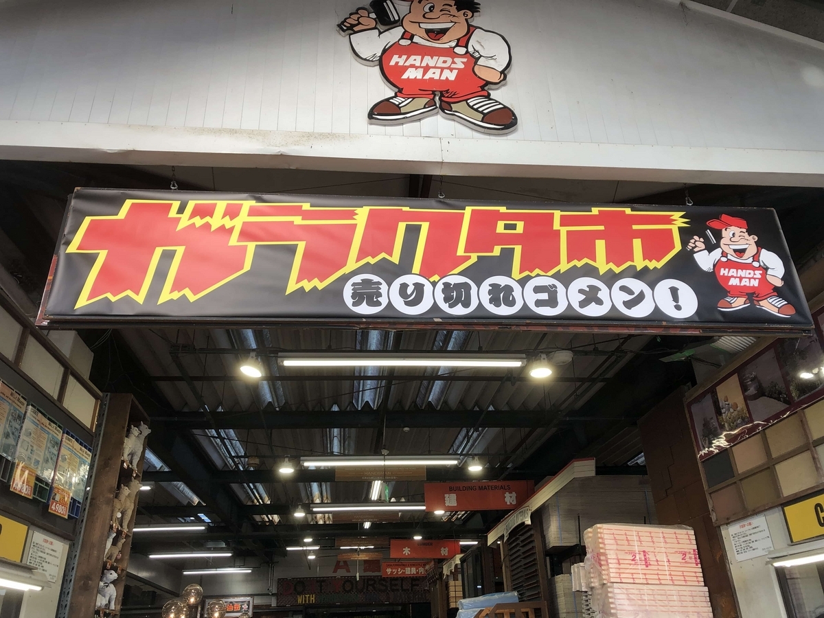 ハンズマン新名爪店の入口。でっかく掲げられたガラクタ市の看板が目を引く。