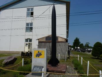 第125特科大隊記念碑と67式30型ロケット弾発射機用の68式30型ロケットりゅう弾.JPG