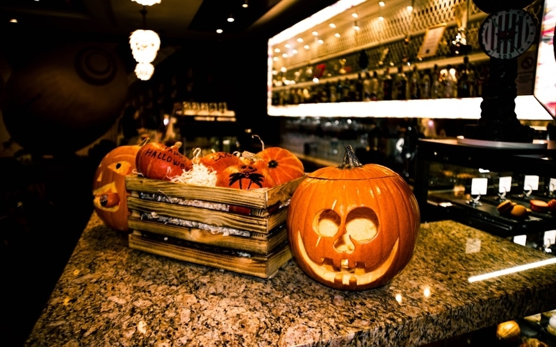ハロウィンの仮装をした人々が、ハロウィン料理を囲んで楽しんでいる様子