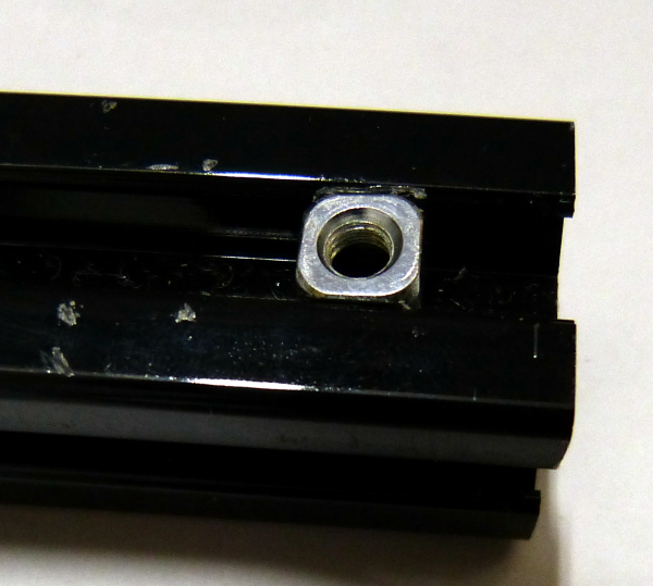 アルミフレームのレールの開放部に、四角ナットが挟まった状態