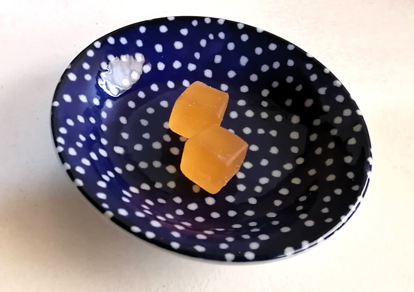 お皿に出したナタデココ・オレンジグミ　オレンジ色の四角いグミ