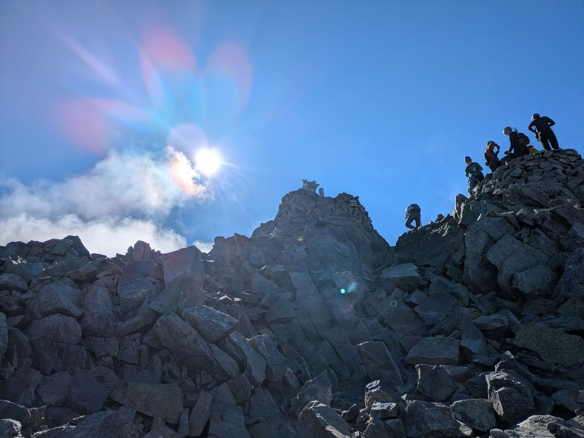 奥穂高岳の山頂。体力があるからこそできる挑戦と、そのためにお金を使うことの大切さを感じさせる風景。