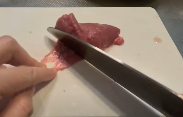 豚の睾丸の皮をはぐ