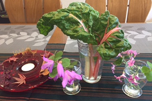 テーブルの上。庭のカタバミと紫蘭、茎がピンクのストライプの葉っぱはスイスチャード