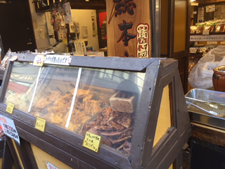 案内所隣の雷神堂巣鴨本店で焼き立てのお煎餅1枚50円を購入