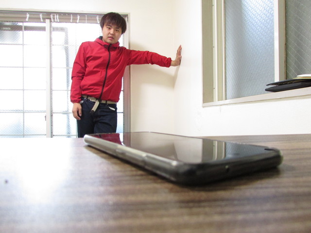 スマホを遠くから眺める男性