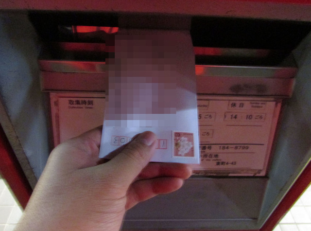 手紙をポストに投函する男性
