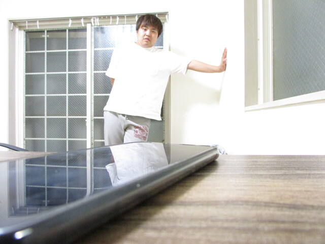 スマホを遠くから眺める男性