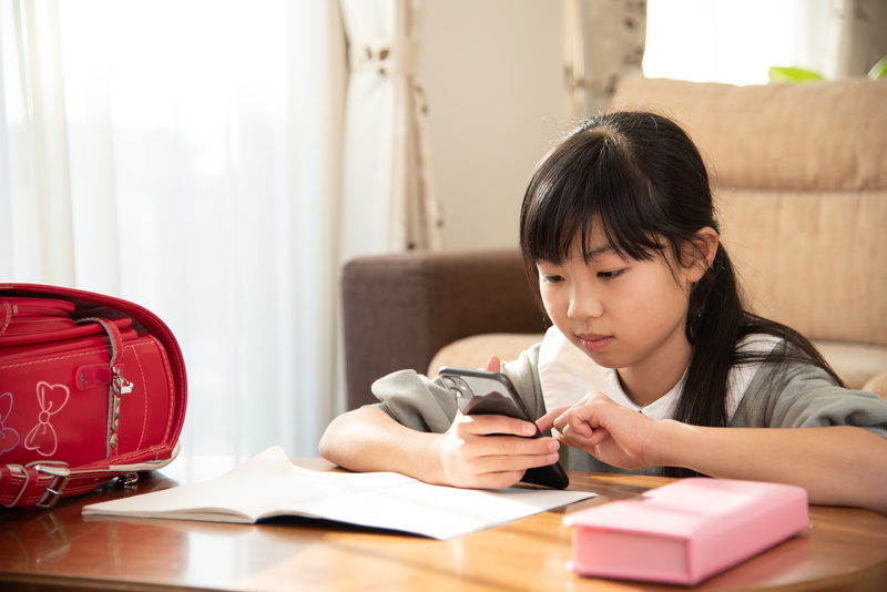 スマホを見る小学生