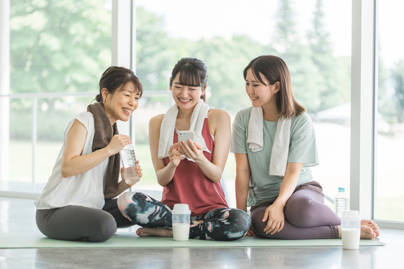 スマホを見ながら運動する女性たち