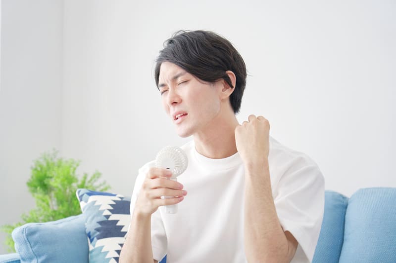ハンディーファンを使用している男性