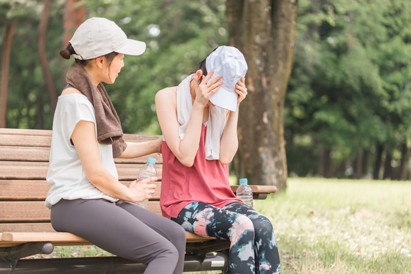 熱中症を訴える女性と介抱する女性