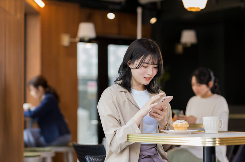 カフェでスマホを操作する女性