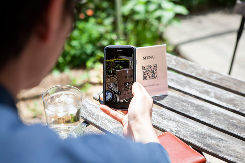 モバイルオーダーのQRコードをスマホで読み込む男性