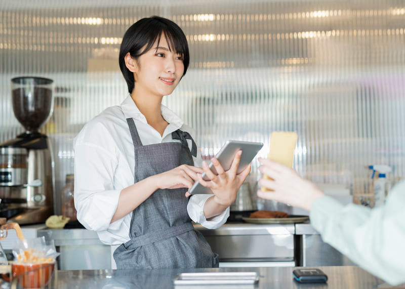 客のモバイルオーダーに応じる女性店員