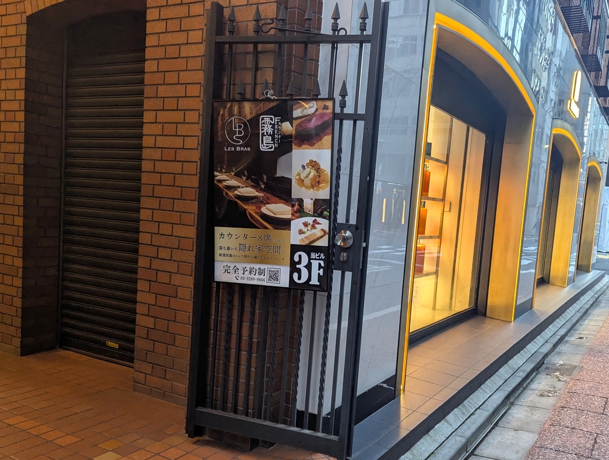 建物入口の案内板にはカウンター8席の隠れ家空間の文字が