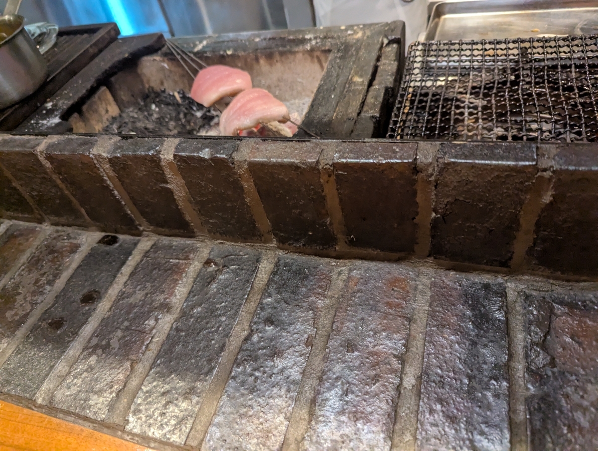 炭火で皮を焼いている最中の金目鯛