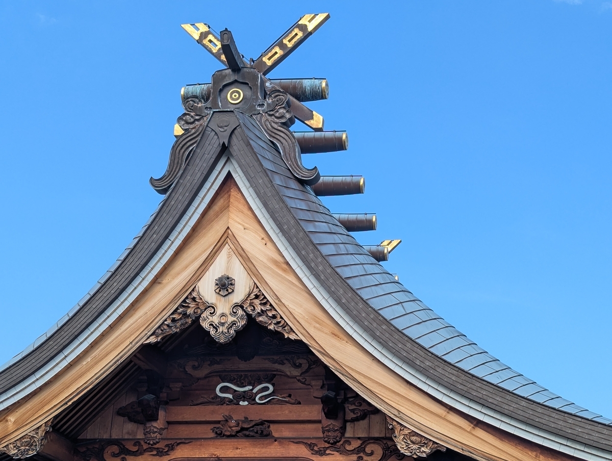 本殿の屋根には、白蛇神社ならではの“蛇”の彫刻や二重丸の蛇の目の社紋が。