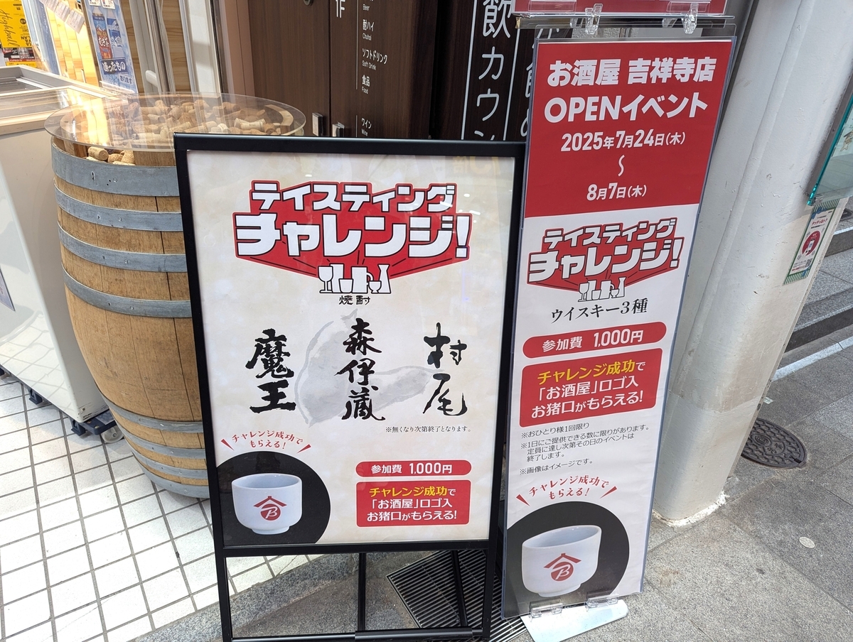 『お酒屋 吉祥寺店』オープン記念イベントの案内看板。ウイスキーと焼酎のテイスティングチャレンジ（各1000円）を実施中で、チャレンジ成功者にはオリジナルお猪口のプレゼントも！