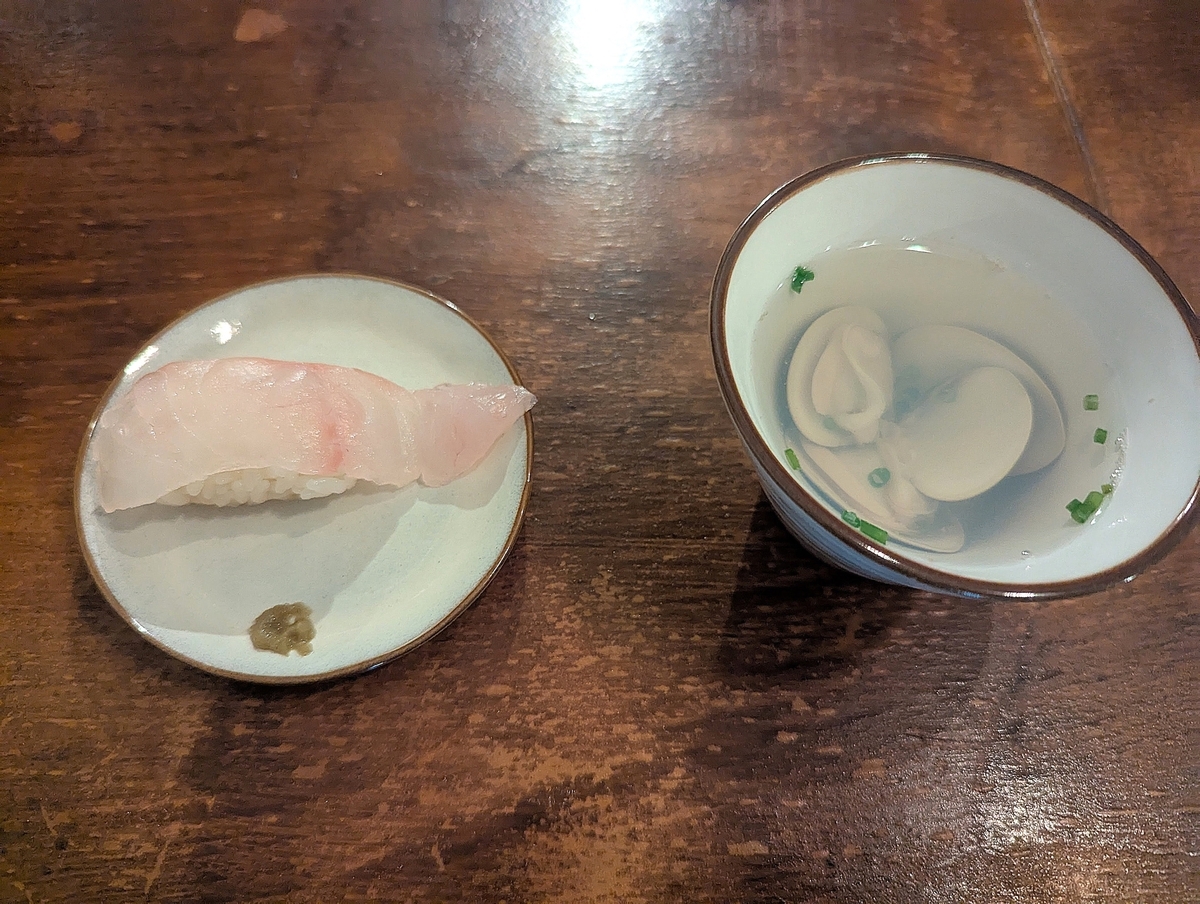 お通しは白身魚のにぎり寿司と、アサリの旨みが凝縮された澄まし汁（500円）。一口目から魚の鮮度を感じられる。