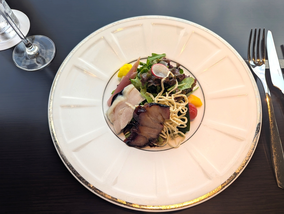 自家製の豚チャーシューと鶏チャーシューを贅沢に盛り付けたシノワサラダ。香ばしさとしっとり感の共演。