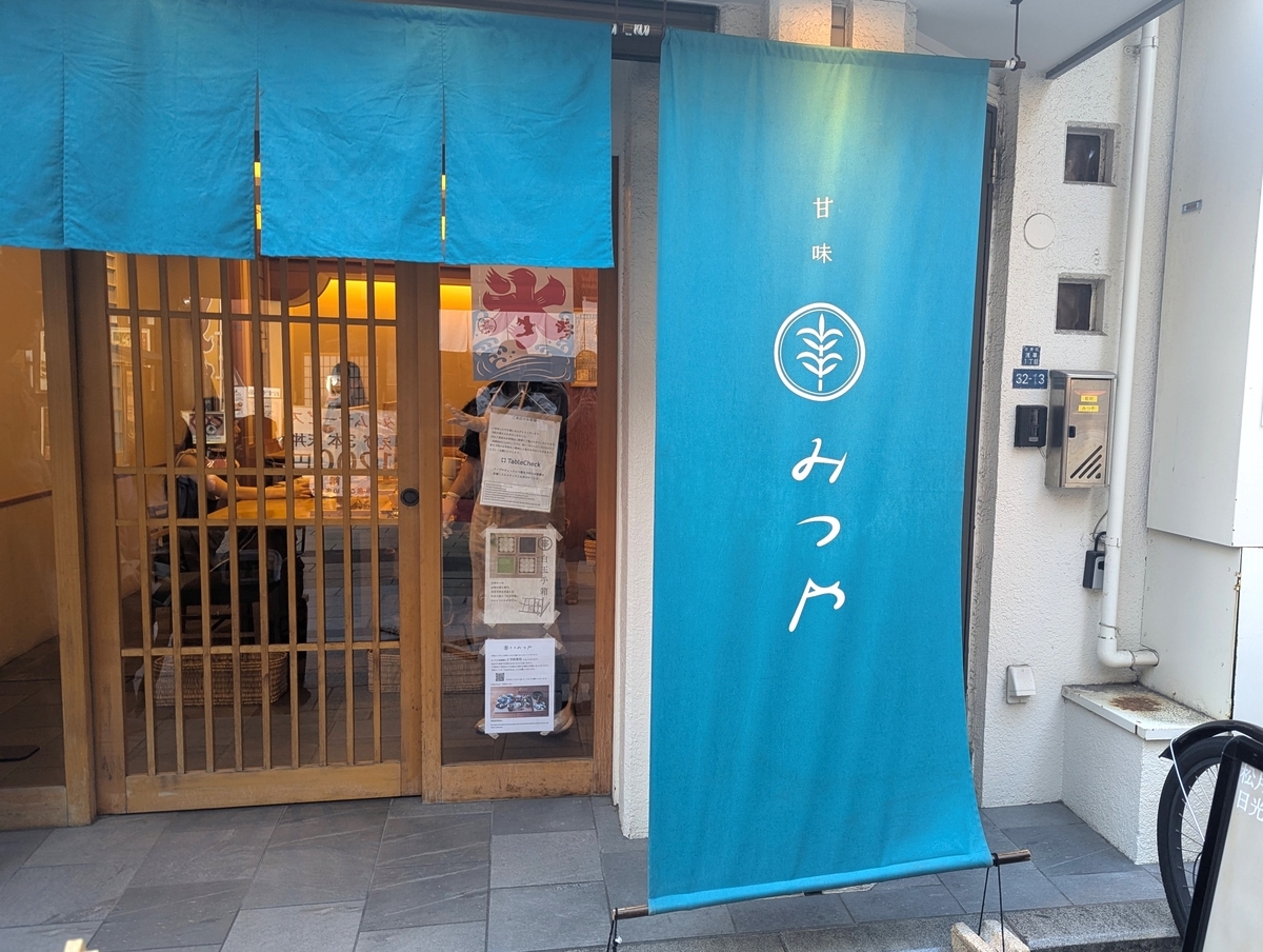 鮮やかなブルーの暖簾が特徴的な「甘味 みつや」店舗外観