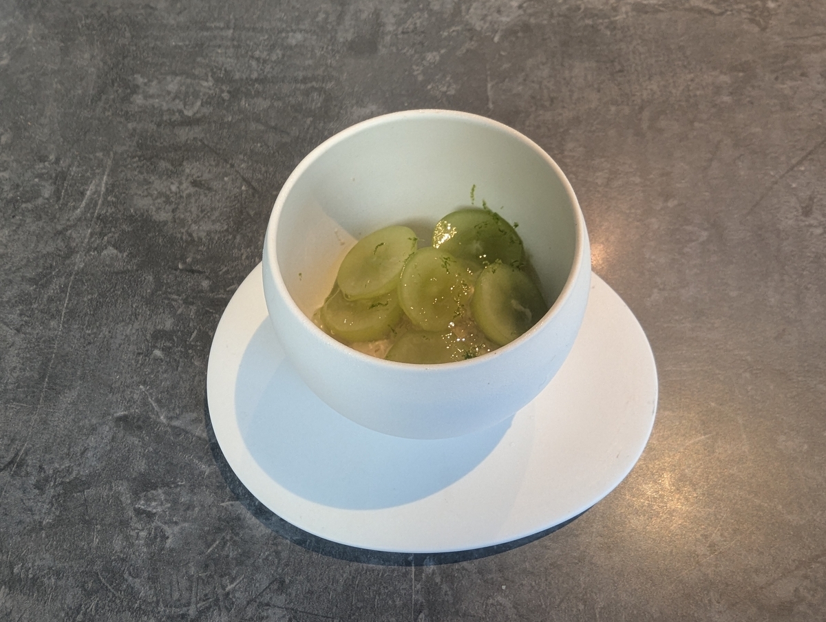 立川のモダンフレンチ『アシメトリィ』で提供された、ダージリンムースにシャインマスカットとかぼすゼリーを重ねたデザート。白い器に盛り付けられた爽やかな一皿。