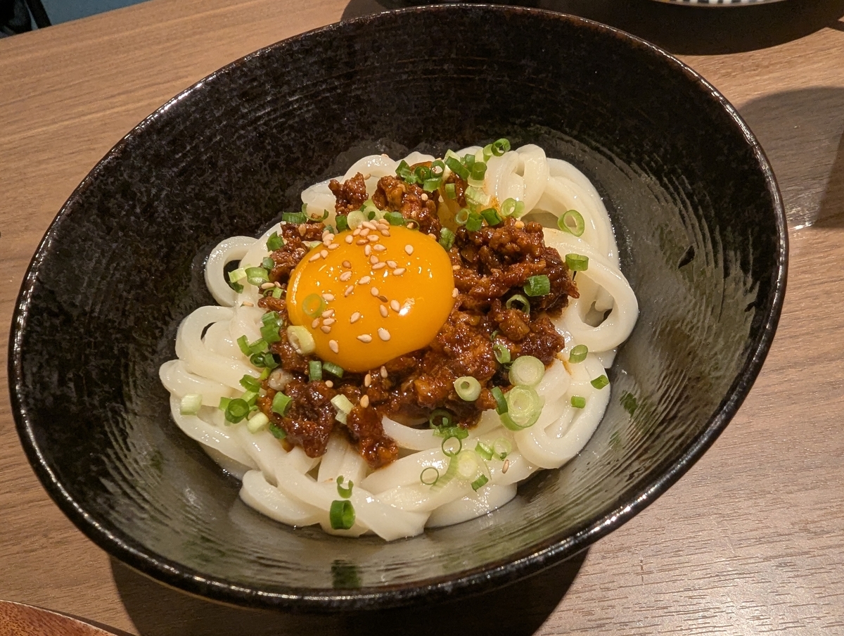 殻YABURI 国分寺店 ゆずたま釜玉うどん 税込825円（ゆずたまの卵黄と肉味噌をのせた濃厚釜玉うどん）