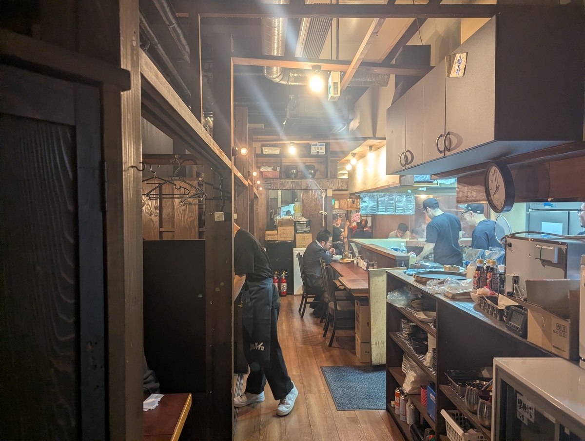 豊田駅すぐの焼鳥どん豊田店の広々とした店内。60席の大箱空間で、カウンター・テーブル席・半個室が揃い、焼き場のライブ感も楽しめるレイアウト。グループ利用もしやすい人気の焼鳥酒場。