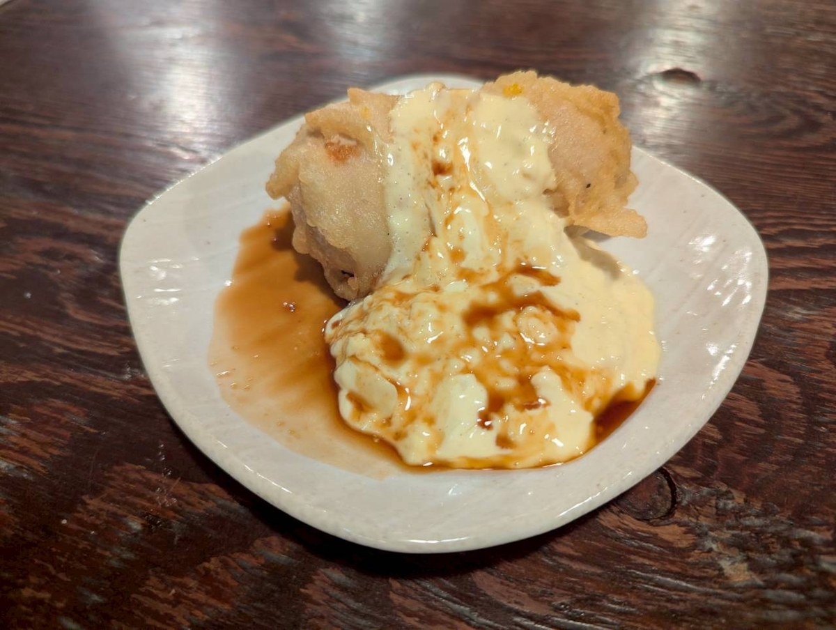 豊田駅の人気焼鳥店『焼鳥どん豊田店』の名物メニュー、揚げたて卵に自家製タルタルソースをたっぷりかけた『タルタル卵』のアップ写真。衣はサクサク、タルタルは卵のコクと甘酸っぱさが濃厚で、とろける質感が特徴。居酒屋グルメ・豊田ディナーのおすすめ料理。