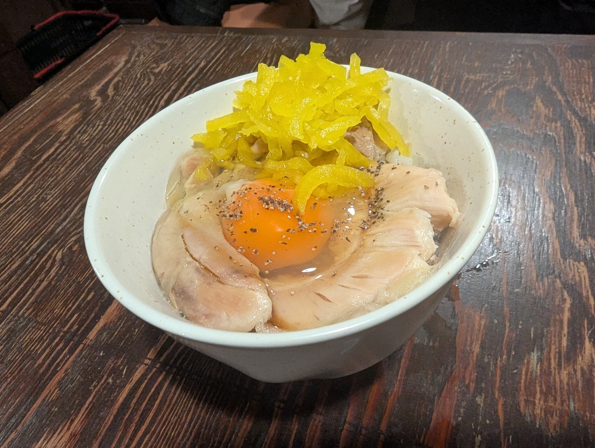 焼鳥どん豊田店の人気〆メニュー『焼鳥どんのTKG』。低温調理のしっとり鶏肉と卵黄、刻みたくあんをのせた贅沢卵かけご飯（499円）。豊田駅の居酒屋で食べられる話題のシメご飯。