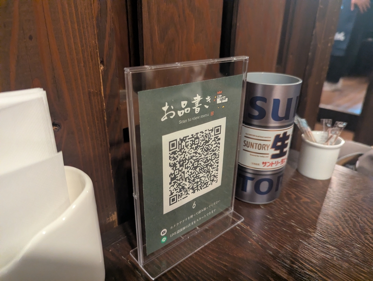 焼鳥どん豊田店の卓上QRコードメニュー。スマホで読み取って注文するセルフオーダー方式で、スムーズに料理を頼める仕組み。