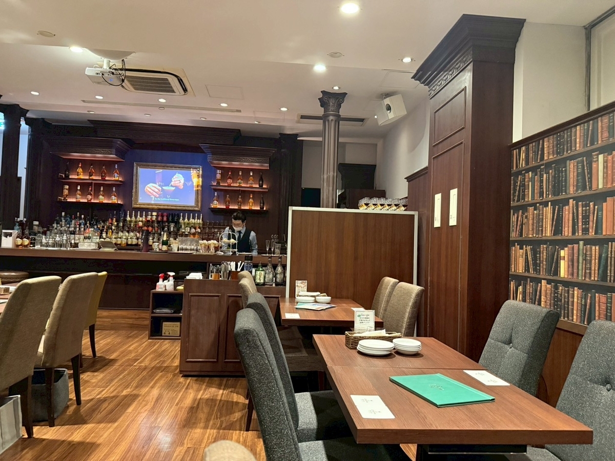 The CHOYA 銀座BARの落ち着いた店内。木目調のインテリアとテーブル席が並ぶ上質な空間。