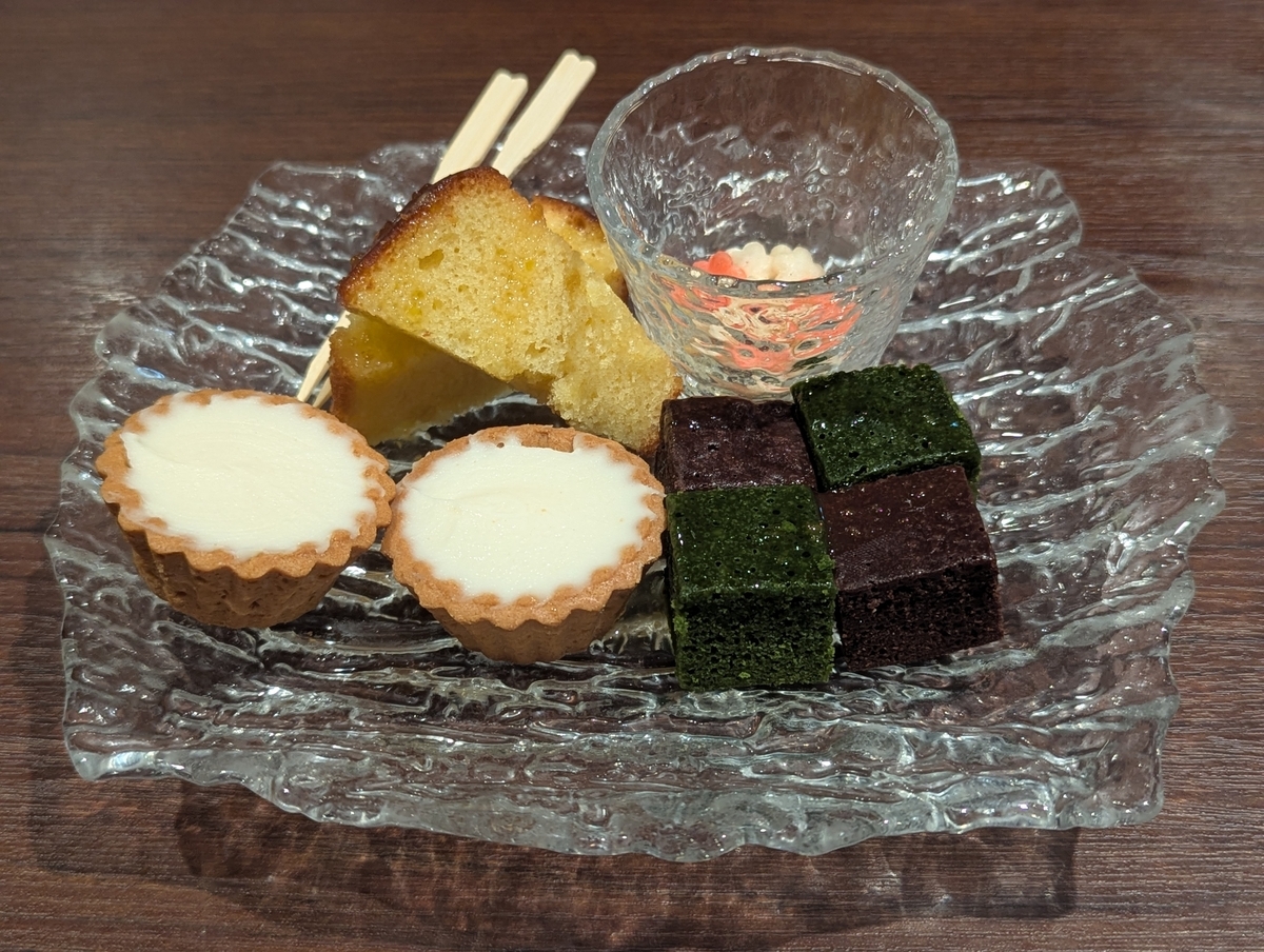 The CHOYA 銀座 BARのプティフール盛り合わせ。ベイクドチーズケーキ（チョコレート・抹茶）、梅のあられ、タルトチーズケーキ、カステラなど、梅の風味を散りばめたスイーツプレート。