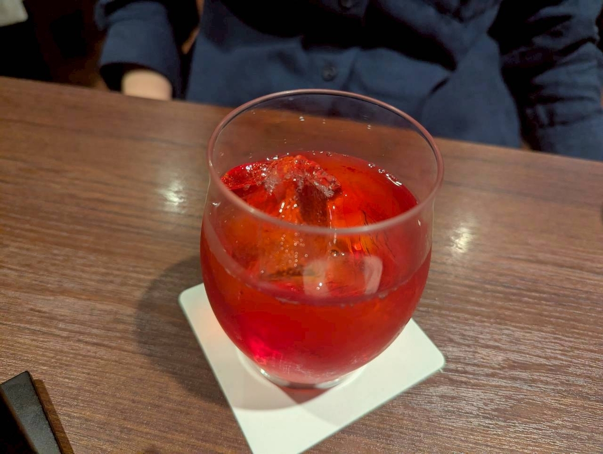 The CHOYA BARで提供されるノンアルコール梅酒カクテル『CHOYAルイボスティー』。酔わないThe CHOYAにルイボスティーとグレナデンシロップを合わせた赤色が美しいノンカクのグラス写真。