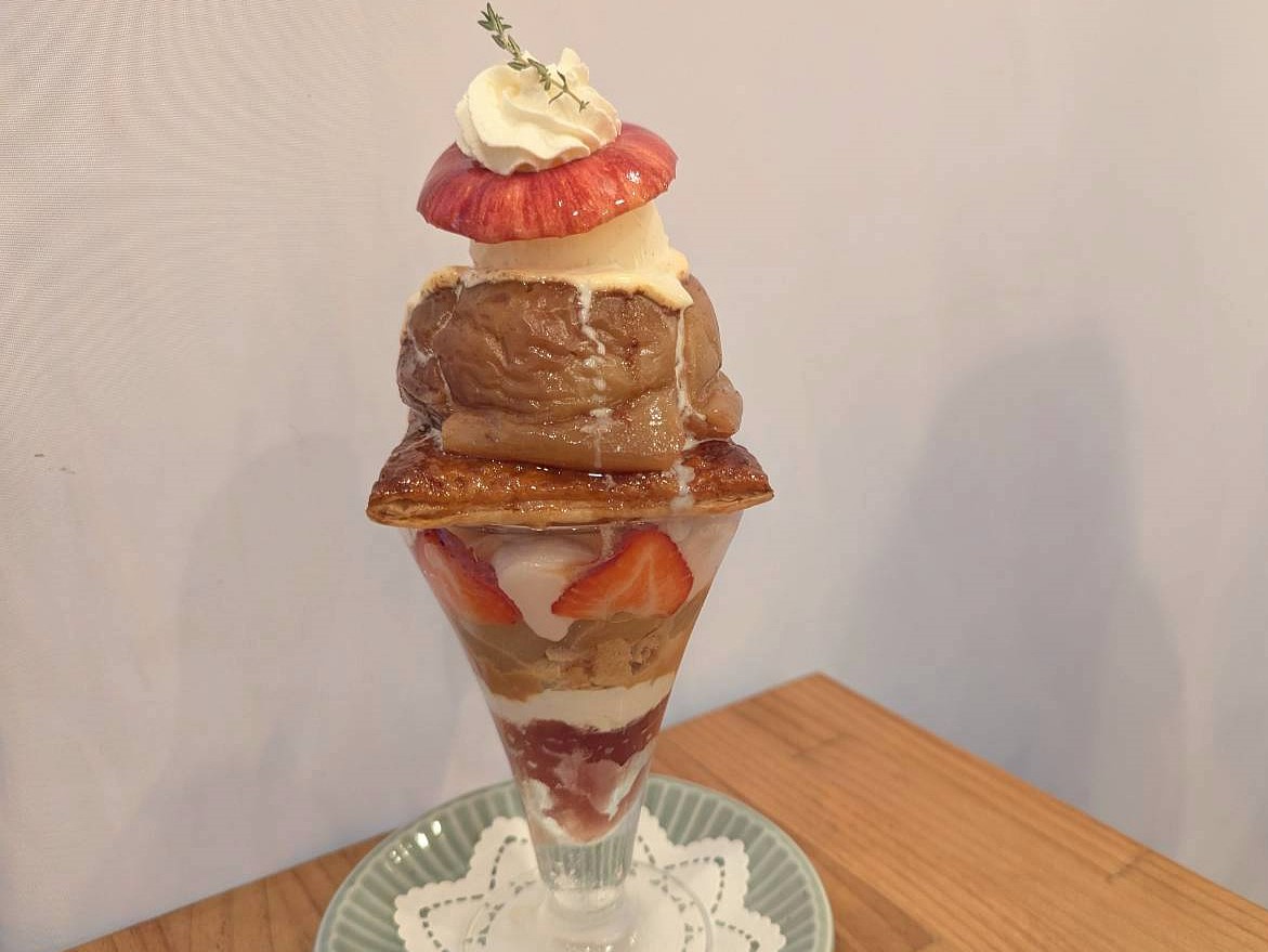 丸ごと焼きりんごといちごのパフェ。バニラアイス、焼きりんご、パイ、いちごクリームが重なるボリューム満点のパフェ。