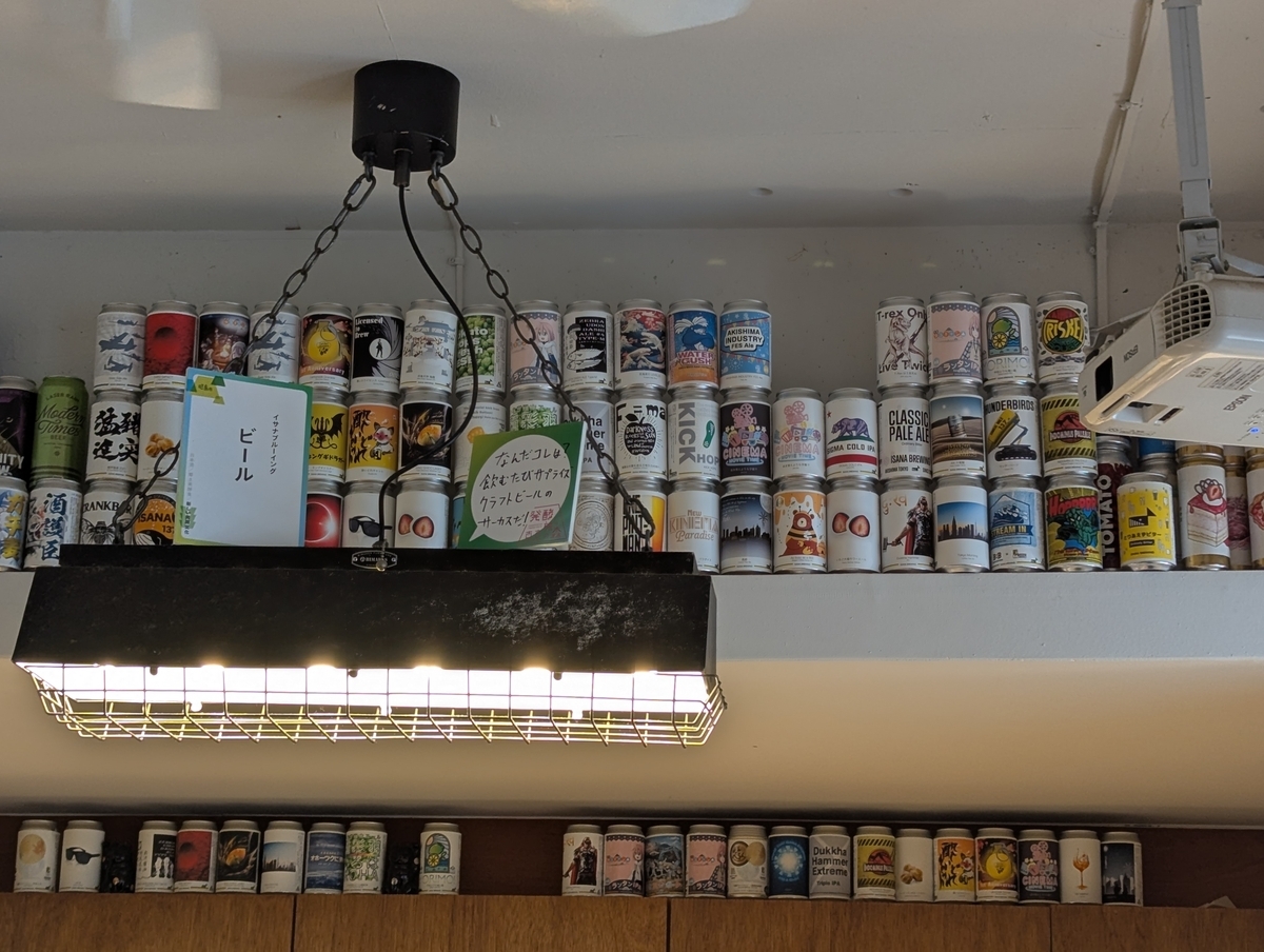 イサナブルーイング店内の天井付近に並ぶ、これまで醸造してきたクラフトビールの空き缶。限定やコラボを含む多彩なラベルが展示されている。