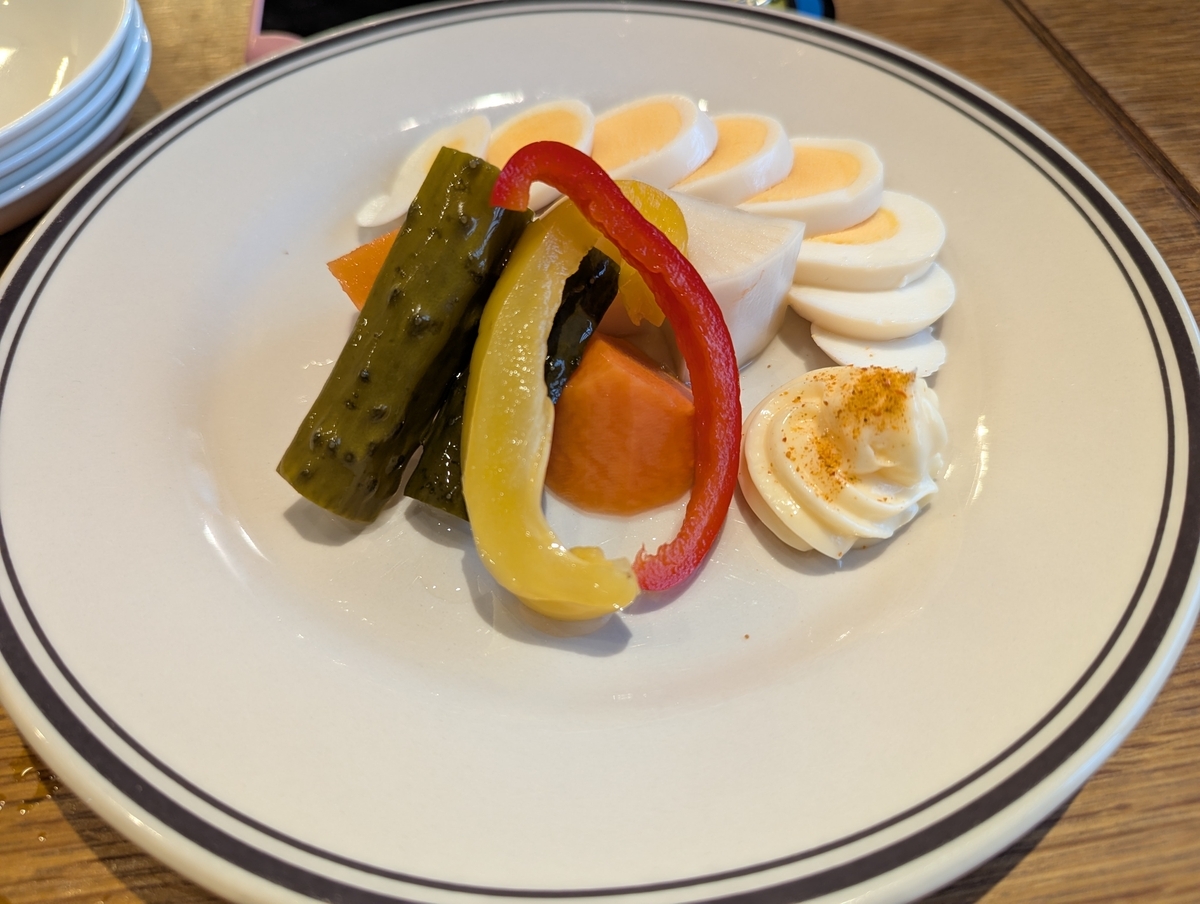 イサナブルーイングの自家製ビールピクルス盛り合わせ。野菜のピクルスと半熟たまごのピクルスが盛られたおつまみプレート